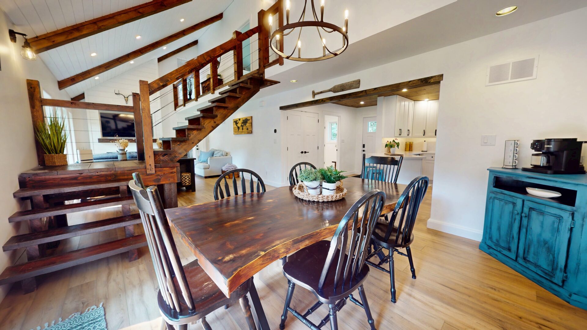 A wood dining table with wood chairs in a white dining room