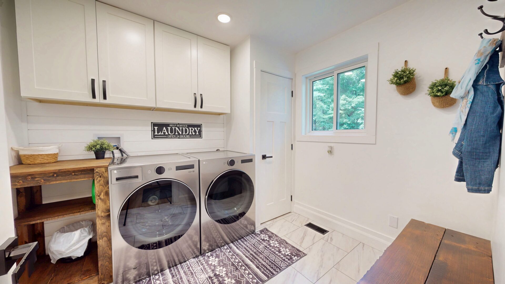 Silver laundry machines on a purple patterned carpet in a white room
