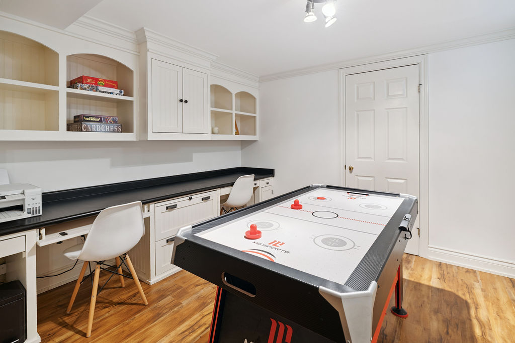 A built-in desk next to an air hockey table