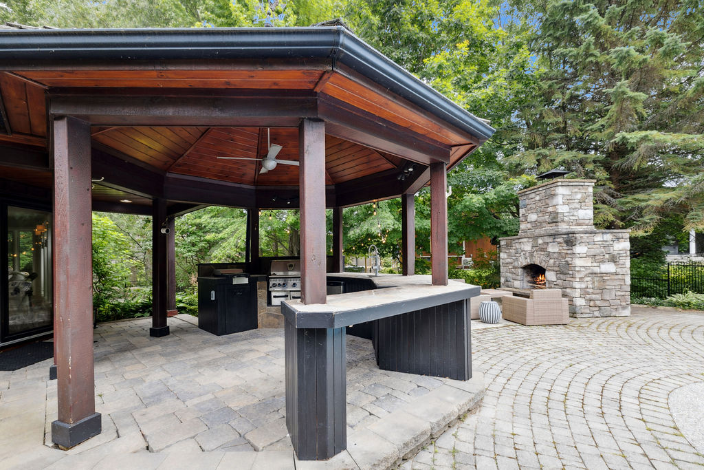 A black and red gazebo on a stone patio