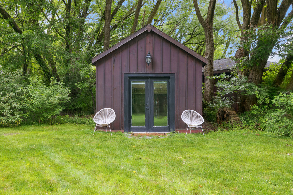 A small wood cabin on a green lawn