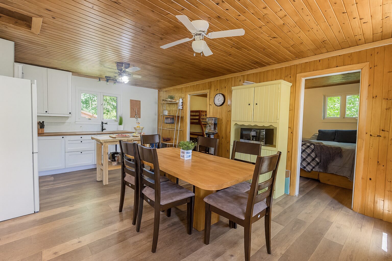 A wood dining table with wood chairs in a cottage dining room