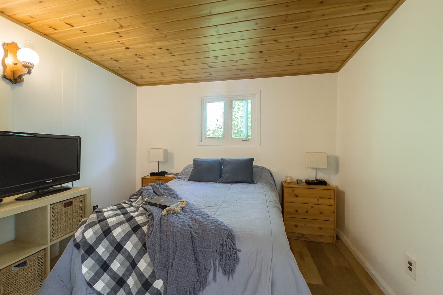 A white bed with a black and white gingham throw