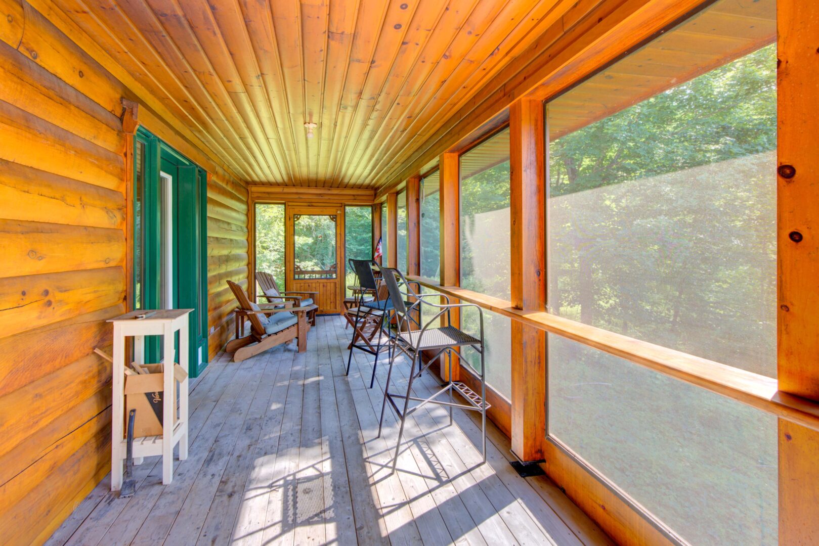 A screened-in porch with a wood paneled ceiling