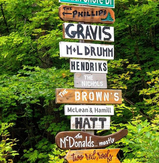 Street sign. Lots. Cottage country. Rural. Northern Ontario. Vacation property home. Cabin. Woods. Arrow. Names. Signpost. Wooden. Wood. Signs. Location. Information. Pride. Ownership. Colorful.