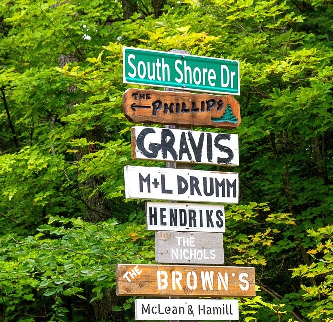 Street sign. Lots. Cottage country. Rural. Northern Ontario. Vacation property home. Cabin. Woods. Arrow. Names. Signpost. Wooden. Wood. Signs. Location. Information. Pride. Ownership. Colorful.