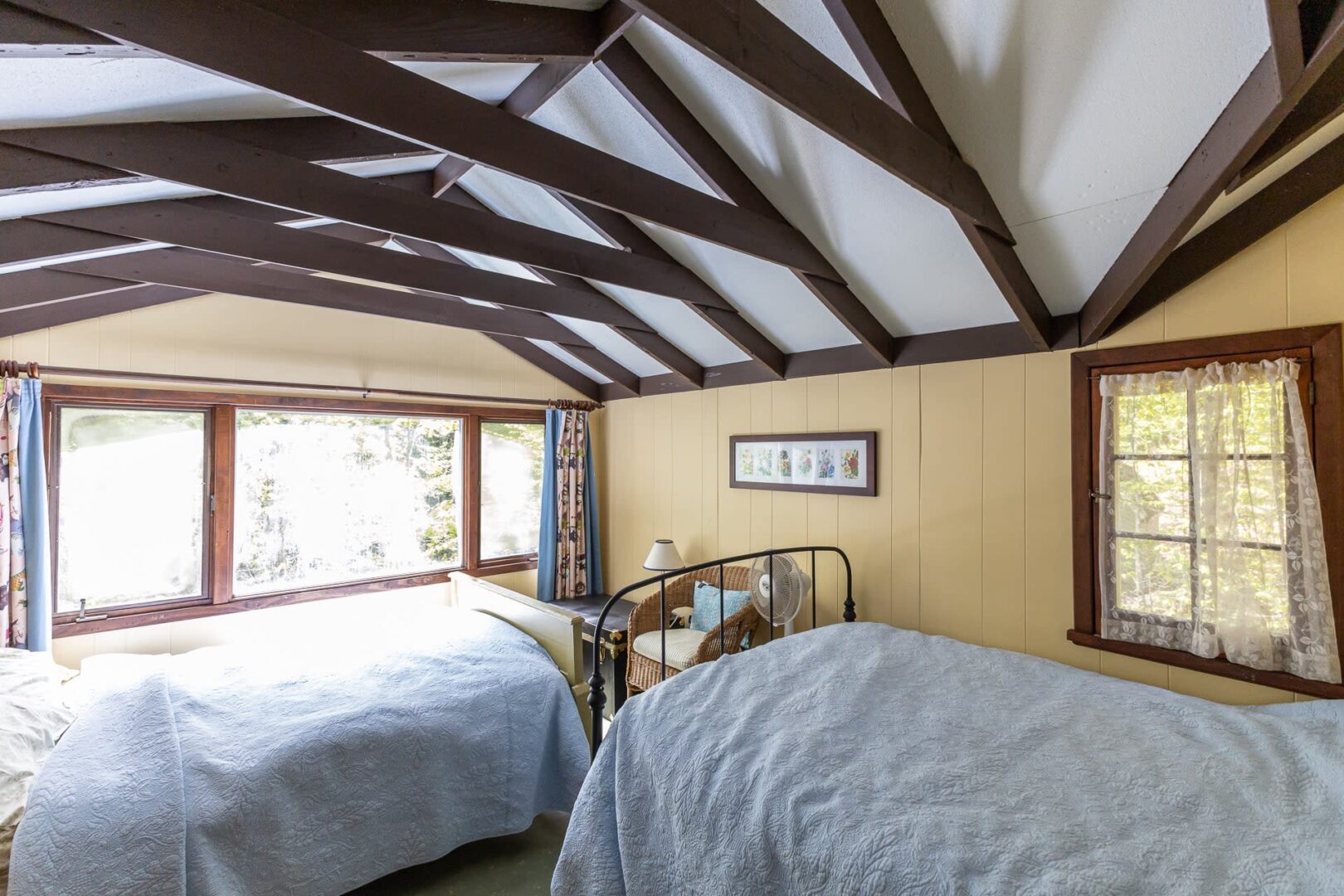 Two light blue beds facing each other in a yellow room