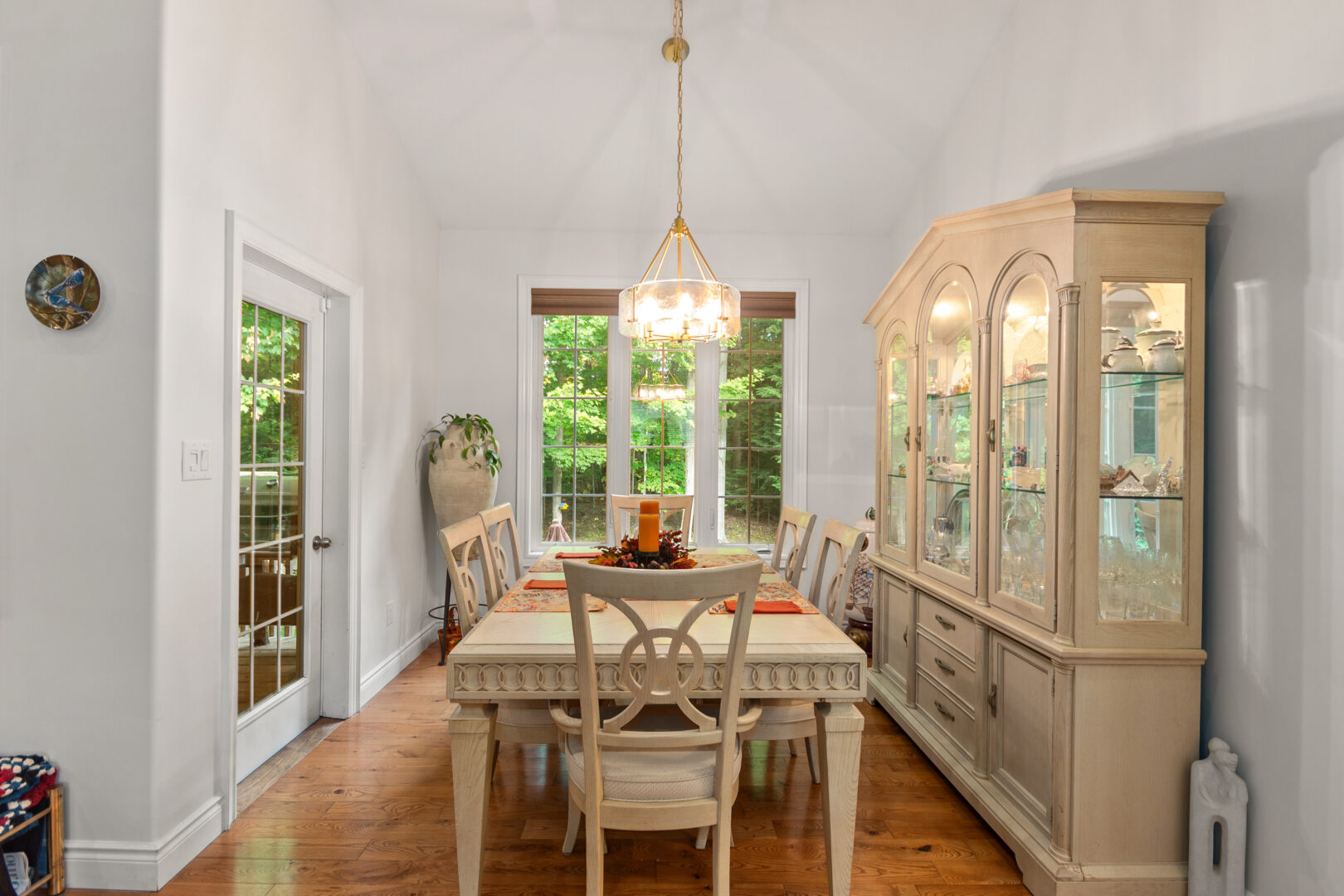 A beige dining table in a white room with windows