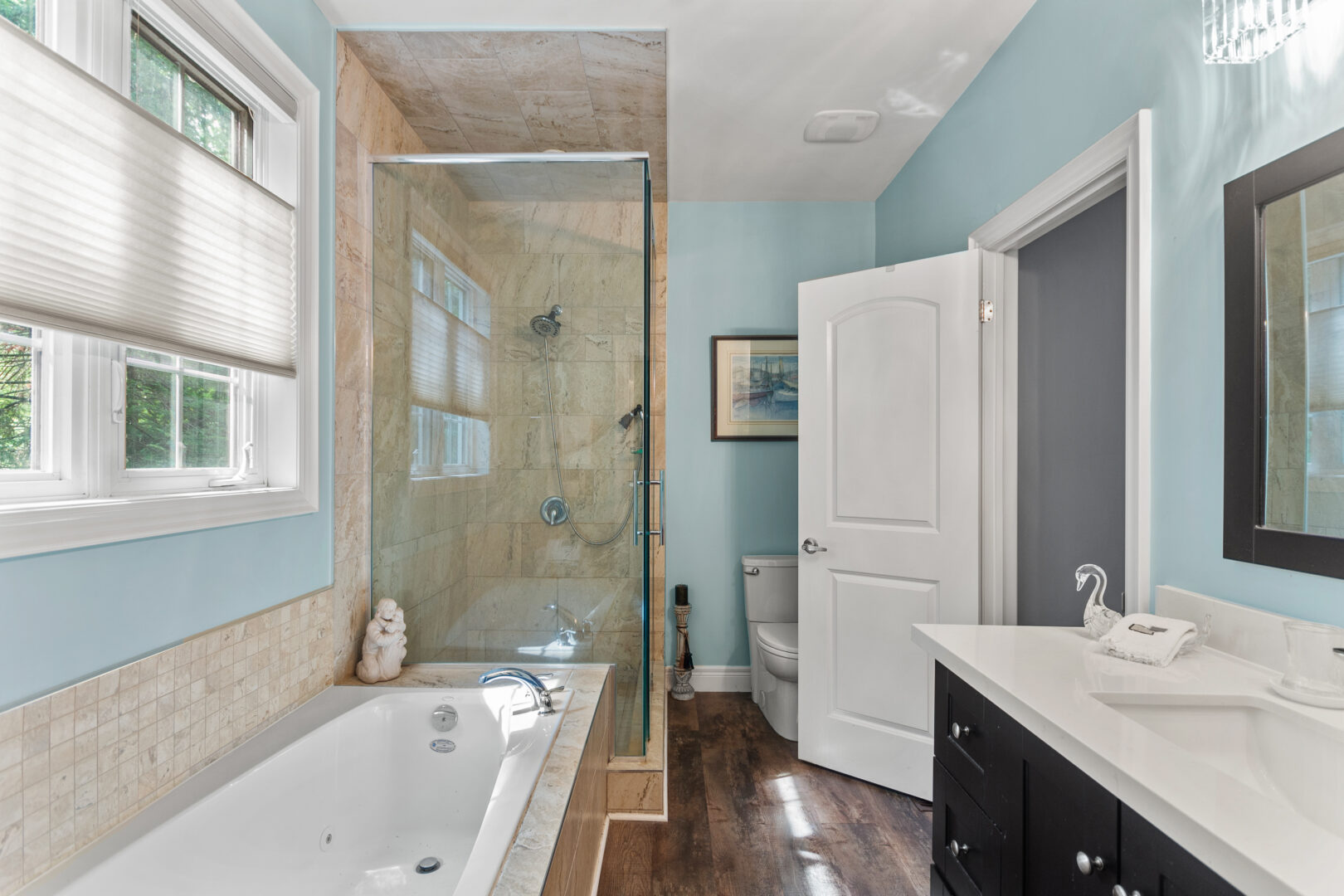 A light blue bathroom with a built-in tub and walk-in glass shower