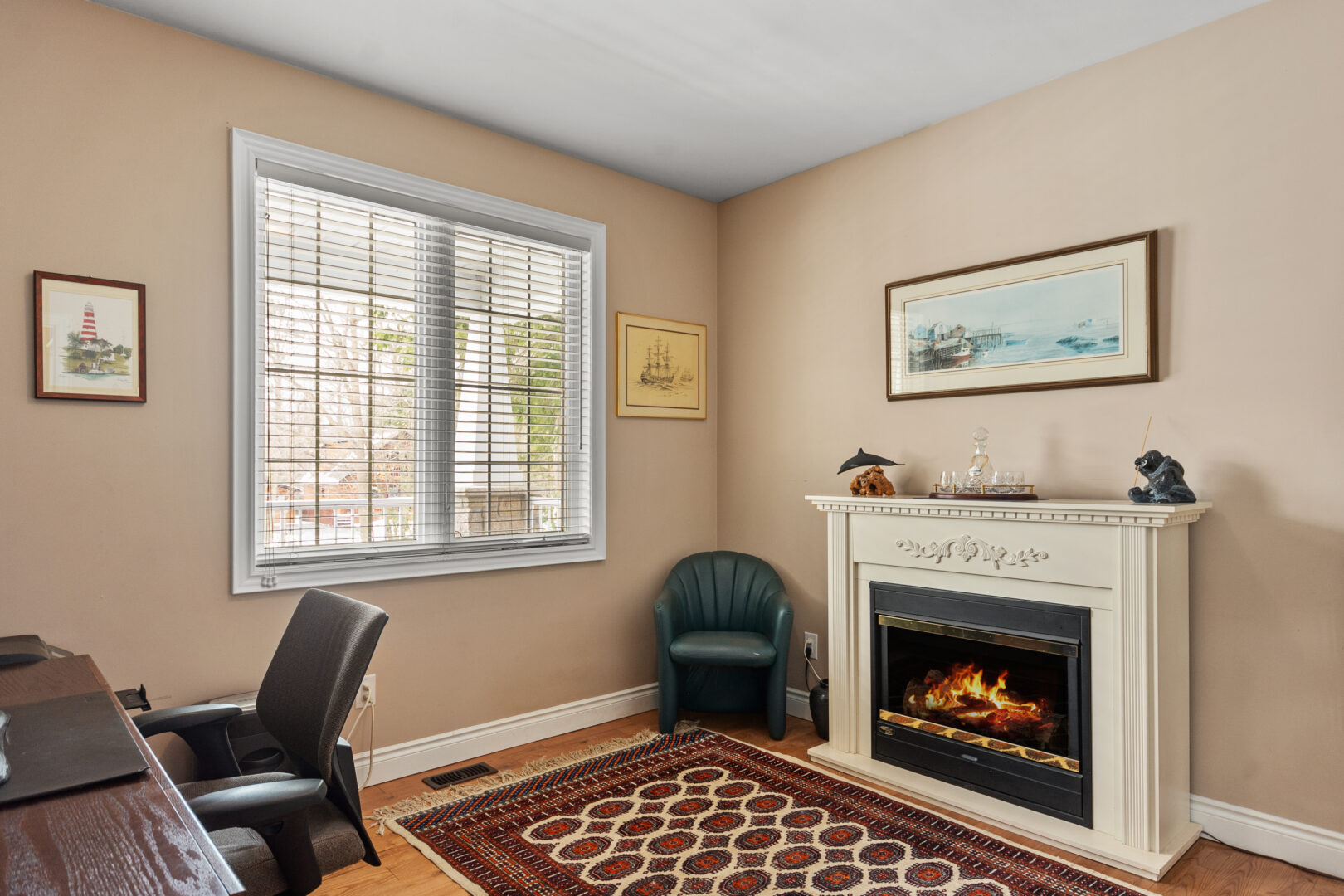 A beige office with a red patterned rug and fireplace