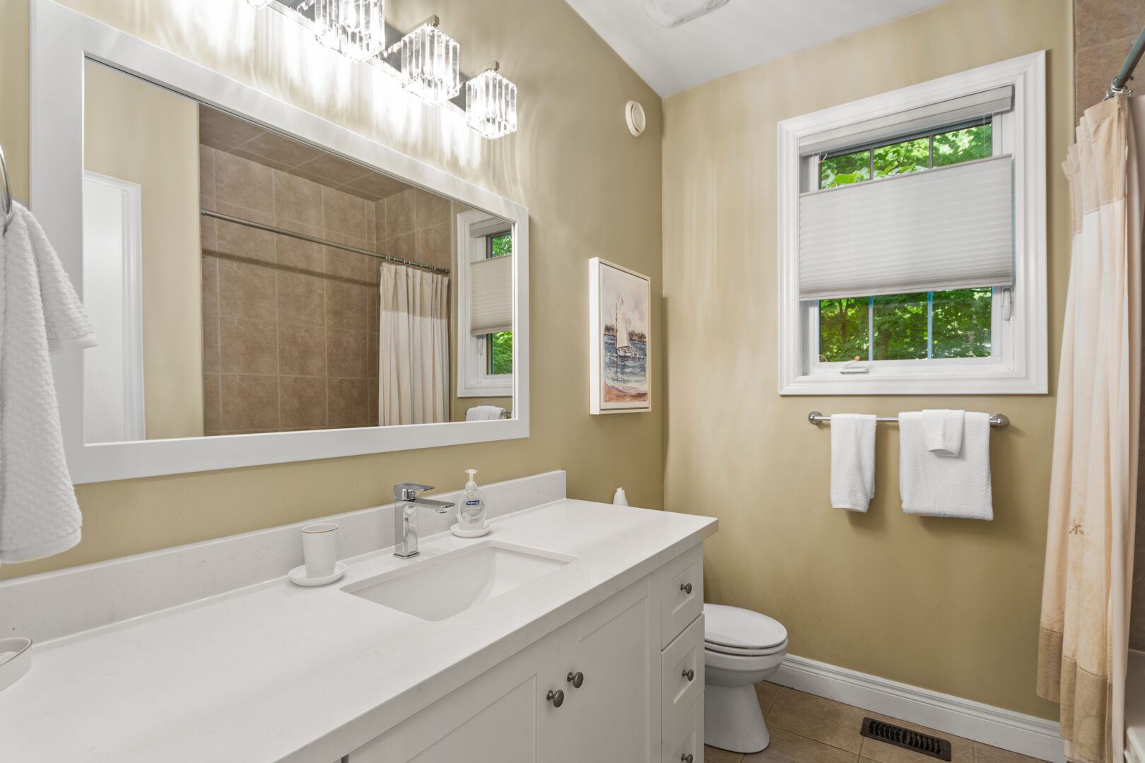 A yellow-beige bathroom with a white vanity