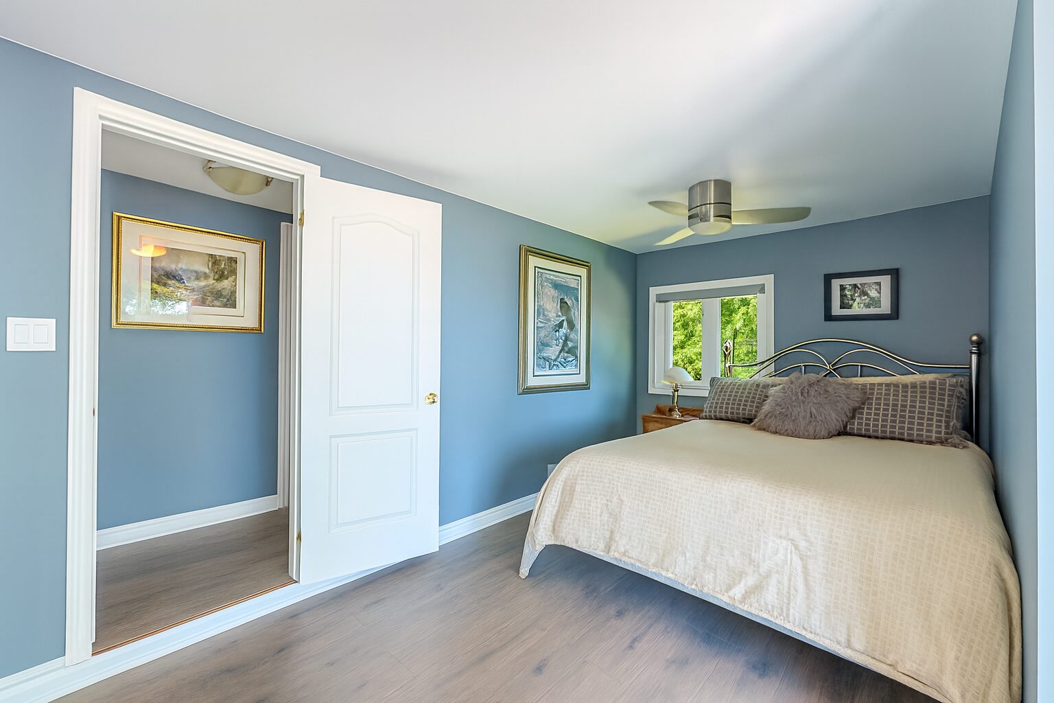 A large white bed in a light blue room