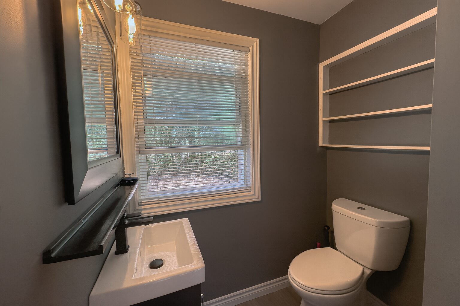 A grey bathroom with white fixtures