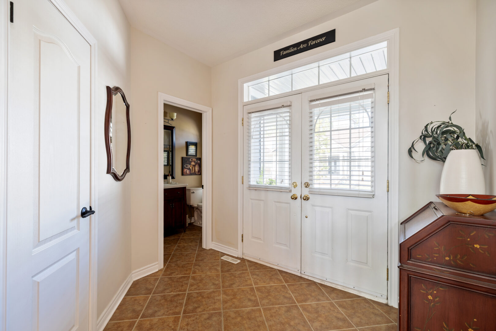 A white entryway with brown floors
