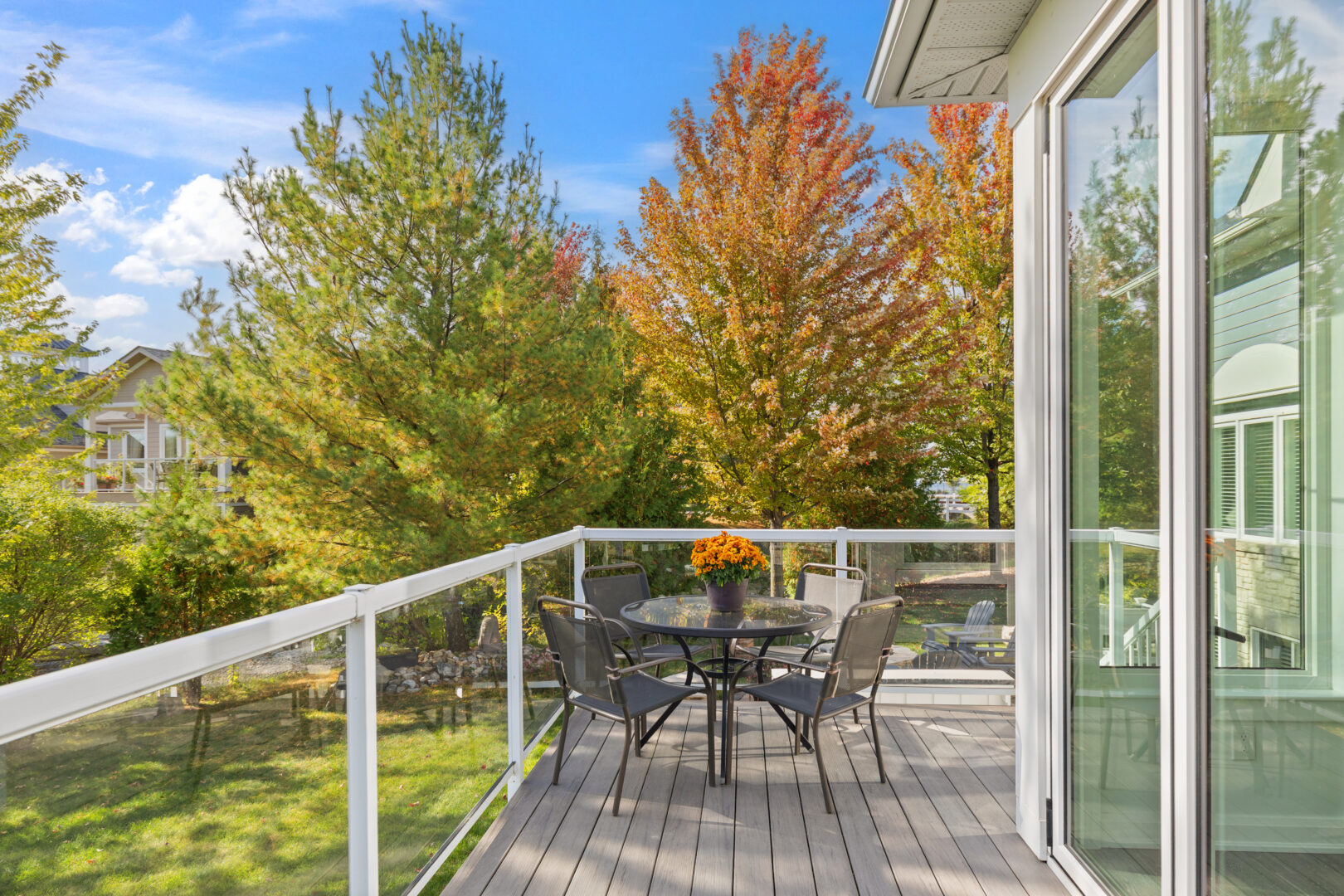 A small sitting area on a deck with glass rails