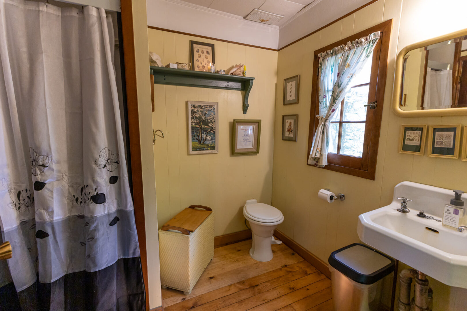 A small beige bathroom with wood floors