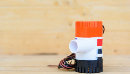 A bilge pump sitting on a wood board