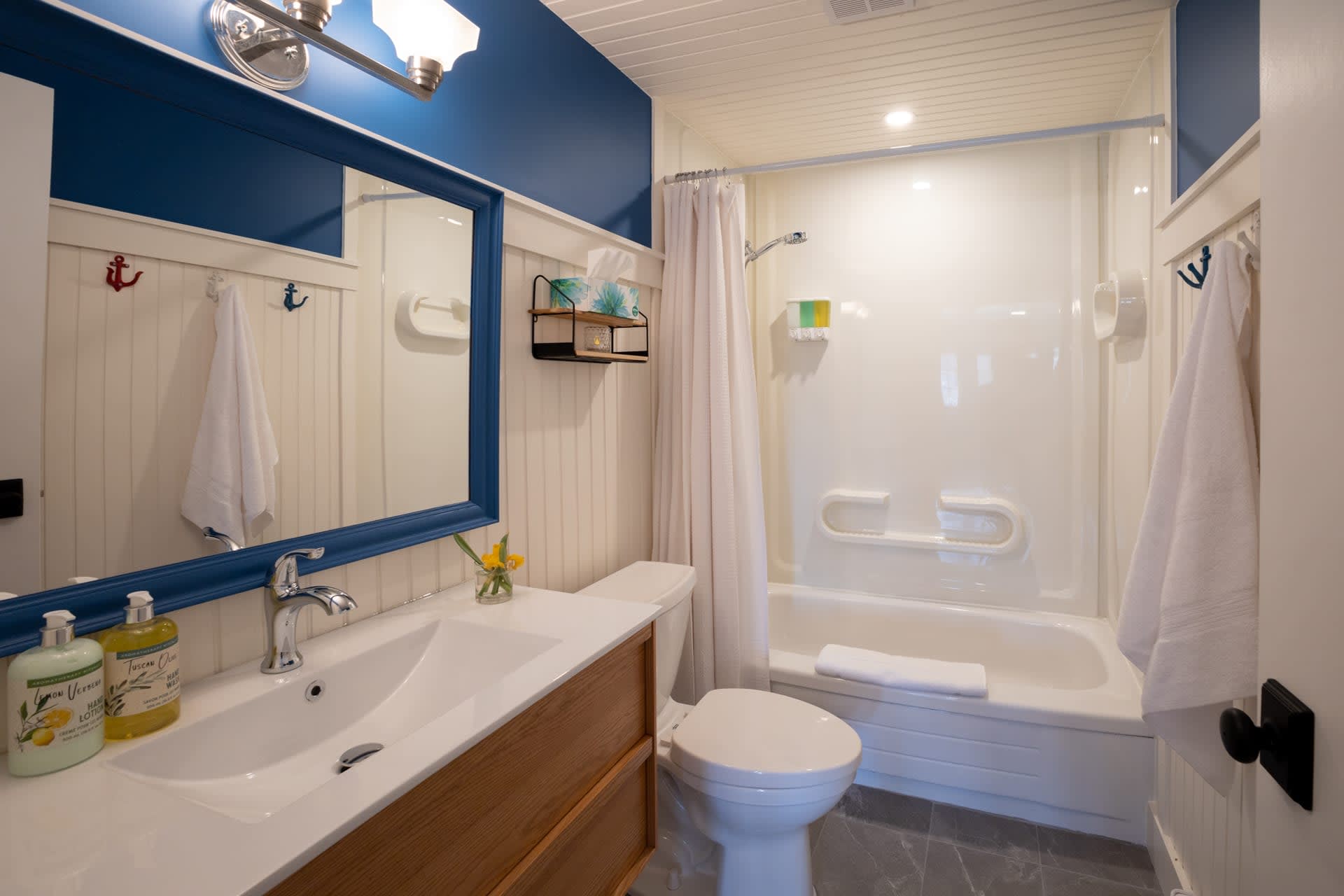 A white bathroom with a wood vanity