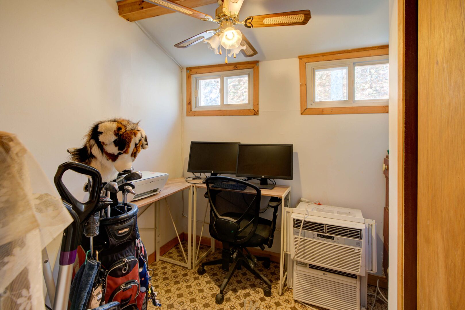 A white office space with a desk, chair and storage