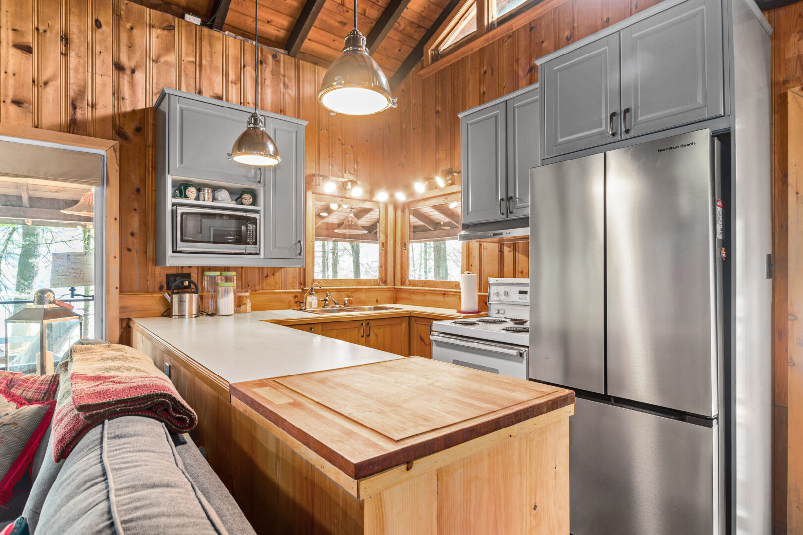 A wood cottage with a wood island and stainless steel appliances