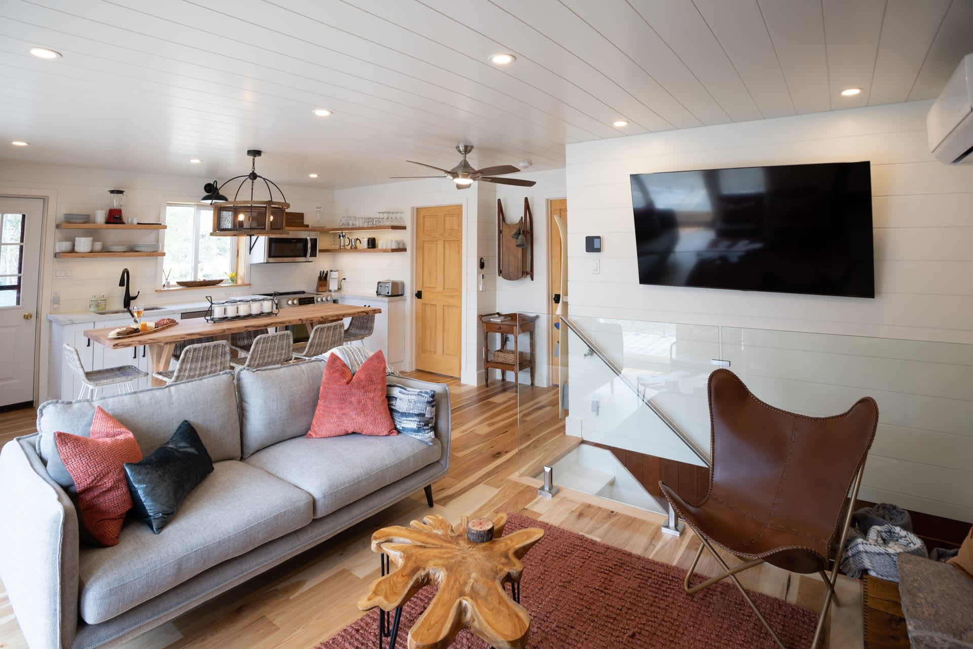 A grey couch faces a granite fireplace