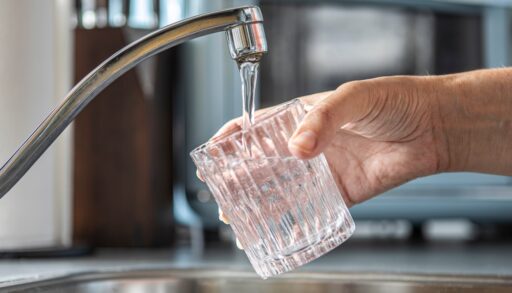 Closeup of a glass being filled with tap water in a kitchen, drinking water