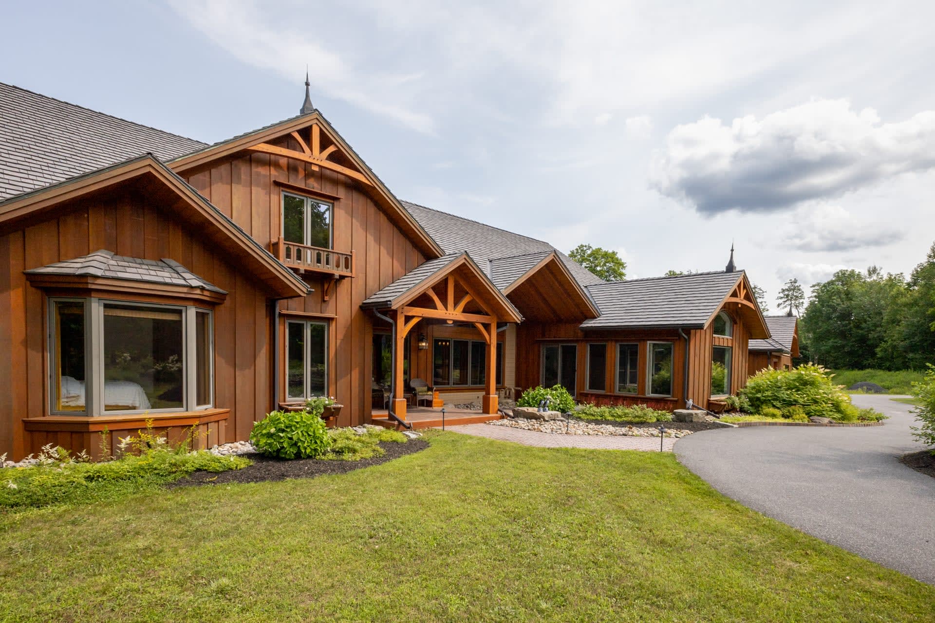 A large log cabin on a grassy lawn