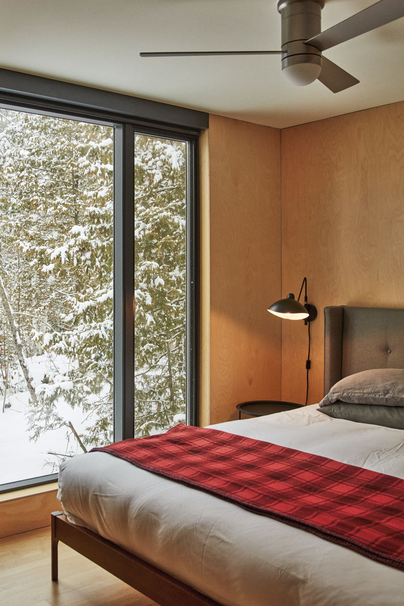 A simple bedroom with a king-sized bed. It's snowy outside
